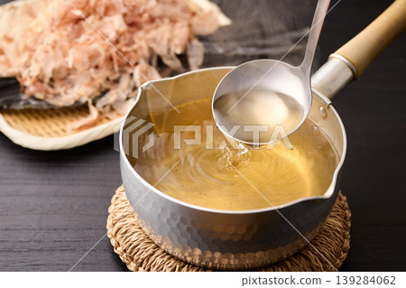 用湯匙舀起滾燙的高湯。 用湯匙舀起滾燙的高湯。 139284062