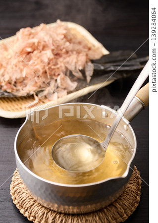 用湯匙舀起滾燙的高湯。 用湯匙舀起滾燙的高湯。 139284064