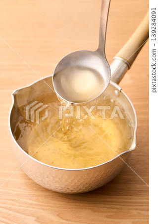 用湯匙舀起滾燙的高湯。 用湯匙舀起滾燙的高湯。 139284091