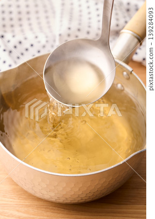 用湯匙舀起滾燙的高湯。 用湯匙舀起滾燙的高湯。 139284093