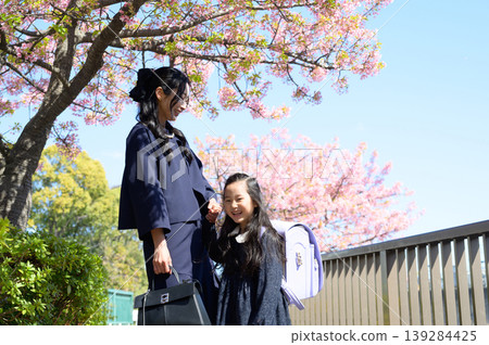 A smiling Japanese parent and child under the cherry blossoms A smiling Japanese parent and child under the cherry blossoms 139284425