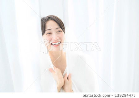 一位三十多歲的日本女子裹在窗簾裡。 一位三十多歲的日本女子裹在窗簾裡。 139284475