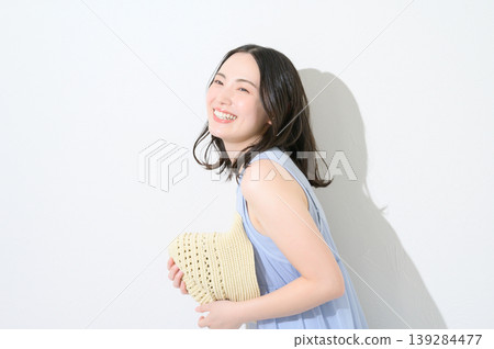一位日本女性手持帽子，在白色背景前，展現出美麗的形象。 139284477