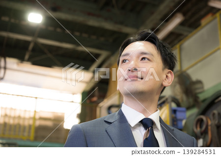 一幅銷售員在工廠裡展望未來的肖像;製造公司、中小企業、信用社和商會的圖片。 一幅銷售員在工廠裡展望未來的肖像;製造公司、中小企業、信用社和商會的圖片。 139284531