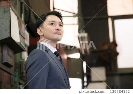 A portrait of a salesman looking towards the future in a factory; images of manufacturing companies, small and medium-sized enterprises, and credit unions and chambers of commerce. A portrait of a salesman looking towards the future in a factory; images of manufacturing companies, small and medium-sized enterprises, and credit unions and chambers of commerce. 139284532