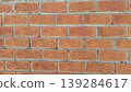 Seamless traditional Thai carved terracotta brick wall pattern, featuring ornate swirl motifs in warm clay tones for architectural design backgrounds. 139284617