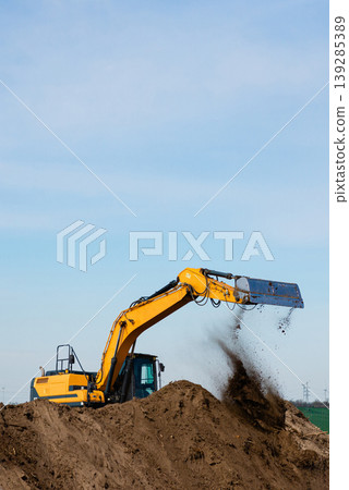 Excavator digging sand on construction site vertical shot Excavator digging sand on construction site vertical shot 139285389