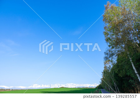 A refreshing early summer blue sky and a view of the Tokachi Mountain Range from Biei Town, Hokkaido. 139285557