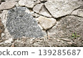 A rough stone wall backdrop, constructed from uneven stones and mortar, offers natural texture, earthy tones and a rustic architectural surface. 139285687