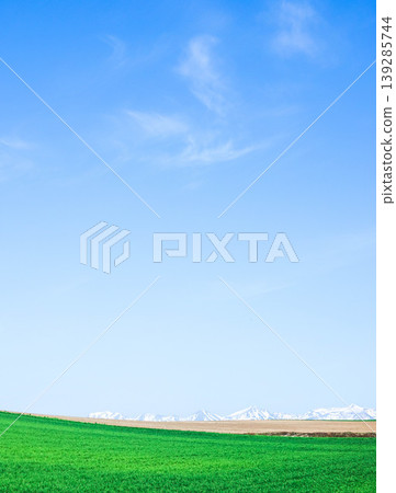 The refreshing blue sky of early summer and the view of the Tokachi Mountain Range from Biei Town, Hokkaido. 139285744