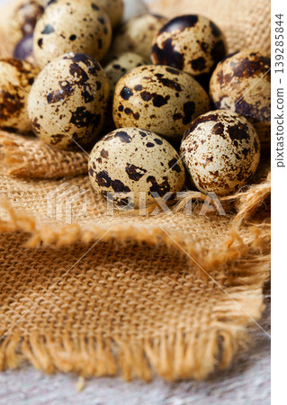 Quail eggs resting on rustic burlap fabric Quail eggs resting on rustic burlap fabric 139285844