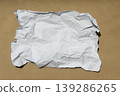 Crumpled paper lying on a brown background. 139286265