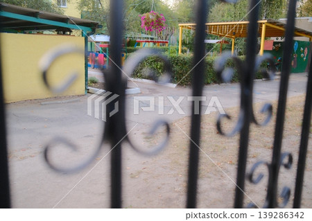 Play area: swings, colorful fence view Play area: swings, colorful fence view 139286342