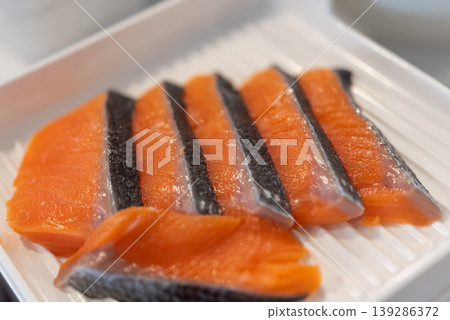 Close up of fresh salmon sashimi slices with skin on white plate rich color and texture premium seafood ready for sushi meal healthy protein and omega nutrition 139286372