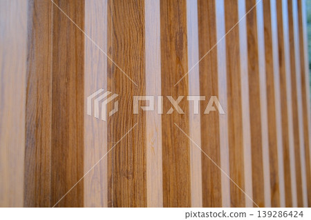 A wooden wall has alternating vertical wood planks 139286424