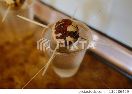 An avocado seed held by toothpicks sits in a clear plastic cup filled with water An avocado seed held by toothpicks sits in a clear plastic cup filled with water 139286459