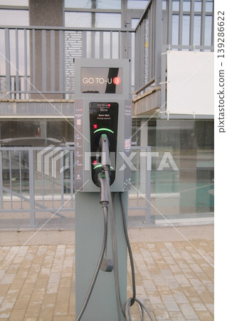 The Go-to-u charging station provides power for electric vehicles near a building 139286622