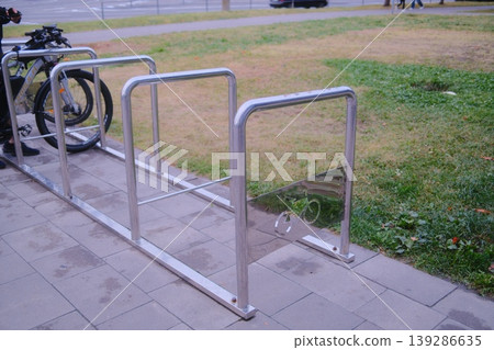 Person places bike into metal parking rack Person places bike into metal parking rack 139286635