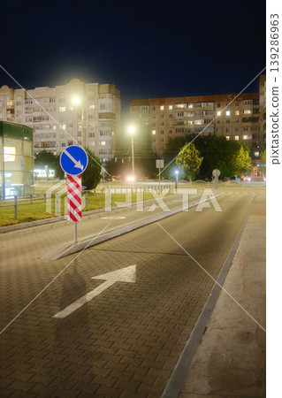 A street shows an arrow and street sign in the evening A street shows an arrow and street sign in the evening 139286963