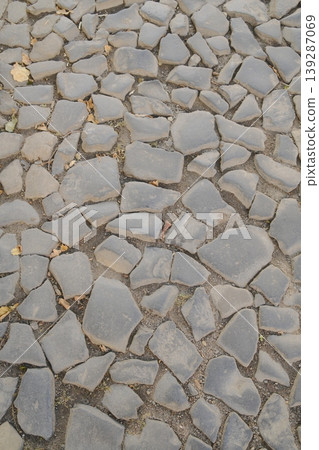 A close-up of a gray cobblestone street surface shows the pavement in Europe A close-up of a gray cobblestone street surface shows the pavement in Europe 139287069