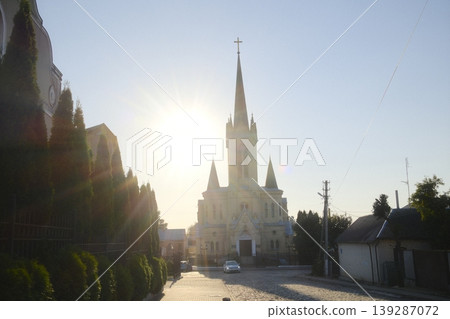Tall Cathedral and car visible on a cobblestone road during a bright, sunny day 139287072