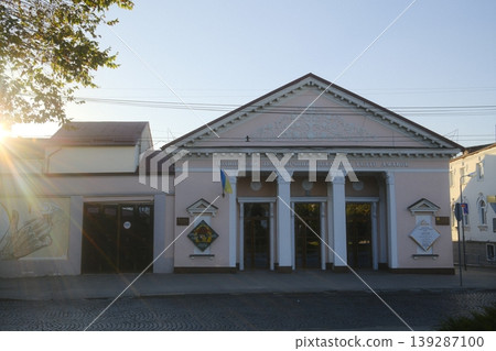 The puppet theater building stands in the sunlight, with a Ukrainian flag at the entrance The puppet theater building stands in the sunlight, with a Ukrainian flag at the entrance 139287100