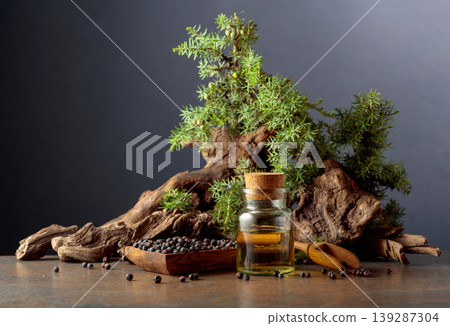 Juniper berry essential oil, berries, and green branches. Juniper berry essential oil, berries, and green branches. 139287304