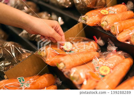 Put a half-price sticker on the carrots. Put a half-price sticker on the carrots. 139288289