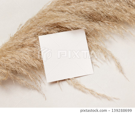 Blank square card mockup on pampas grass and beige stone top view, boho wedding stationery 139288699