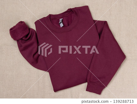 Blank dark red unisex sweatshirt mockup, folded flat lay with copy space on front and sleeve Blank dark red unisex sweatshirt mockup, folded flat lay with copy space on front and sleeve 139288713