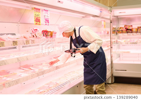 A clerk managing inventory at a supermarket A clerk managing inventory at a supermarket 139289040
