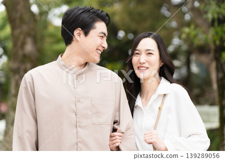 一張年輕男女在公園散步的生活照。 139289056