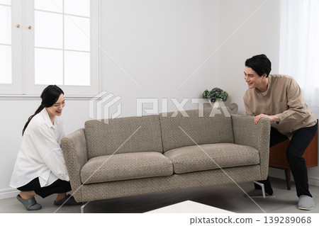 A young man and woman carrying furniture - Lifestyle image A young man and woman carrying furniture - Lifestyle image 139289068
