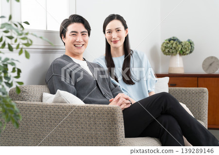 A young man and woman relaxing on a sofa: Lifestyle image 139289146