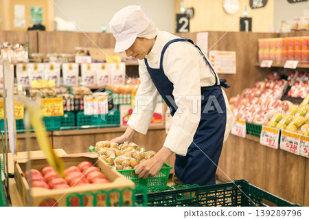 A store clerk organizing merchandise A store clerk organizing merchandise 139289796