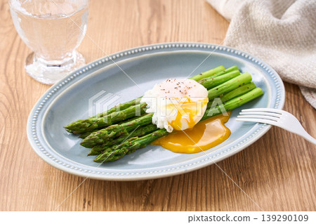 Sautéed green asparagus topped with a poached egg Sautéed green asparagus topped with a poached egg 139290109