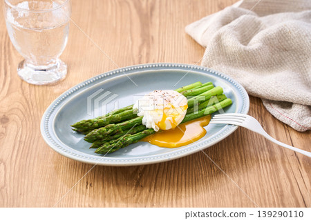 Sautéed green asparagus topped with a poached egg Sautéed green asparagus topped with a poached egg 139290110