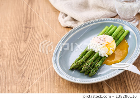 Sautéed green asparagus topped with a poached egg Sautéed green asparagus topped with a poached egg 139290116