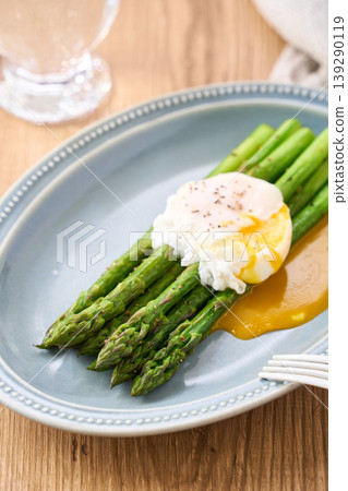 Sautéed green asparagus topped with a poached egg Sautéed green asparagus topped with a poached egg 139290119