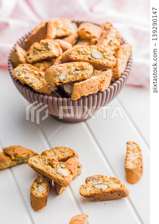 Grissini. Almond Biscotti in Bowl and Scattered Cookies on White Table for Breakfast Snack 139290147