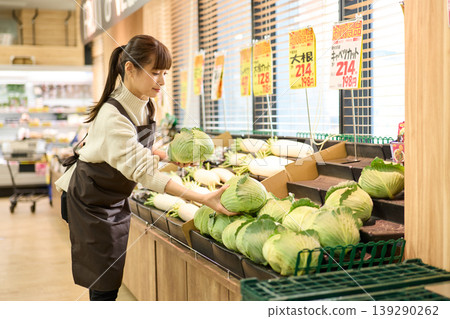 一名商店員工正在蔬果區整理貨架。 139290262
