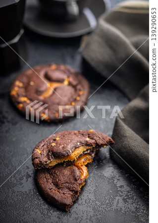 Gooey Caramel Filled Chocolate Cookies Stacked With Coffee Cup Dark Moody Dessert Close-Up Gooey Caramel Filled Chocolate Cookies Stacked With Coffee Cup Dark Moody Dessert Close-Up 139290653