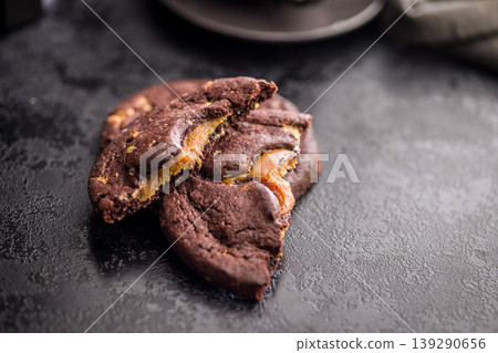 Gooey Caramel Filled Chocolate Cookies Stacked With Coffee Cup Dark Moody Dessert Close-Up 139290656