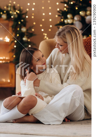 Embracing each other. Mother and daughter are celebrating New Year at home in domestic room 139290900