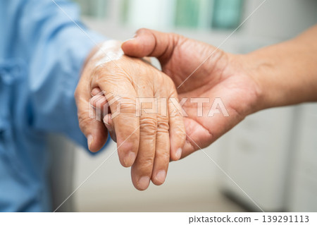 Caregiver holding hands Asian elderly woman patient, help and care in hospital. Caregiver holding hands Asian elderly woman patient, help and care in hospital. 139291113