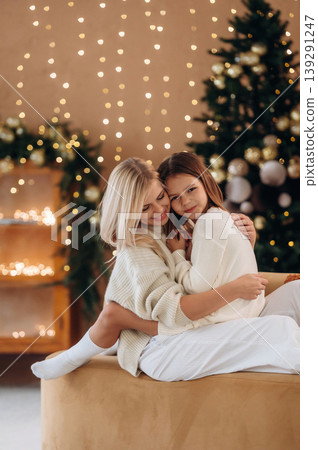 Christmas decorations. Mother and daughter are celebrating New Year at home in domestic room Christmas decorations. Mother and daughter are celebrating New Year at home in domestic room 139291247