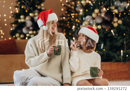 Tasty cookies and tea. Mother and daughter are celebrating New Year at home in domestic room 139291272
