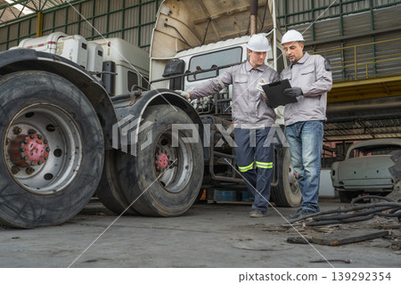 Caucasian and Middle Eastern mid-adult male technicians walk through an Asian container yard while holding a clipboard Caucasian and Middle Eastern mid-adult male technicians walk through an Asian container yard while holding a clipboard 139292354