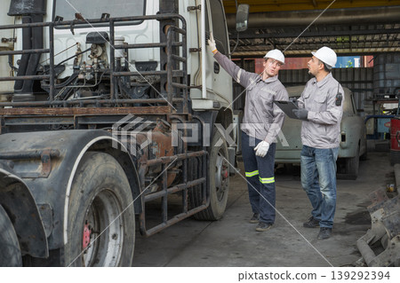 Caucasian and Middle Eastern mid-adult male technicians walk through an Asian container yard while holding a clipboard Caucasian and Middle Eastern mid-adult male technicians walk through an Asian container yard while holding a clipboard 139292394