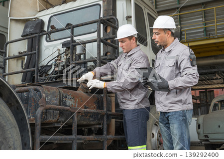 Caucasian and Middle Eastern mid-adult male technicians walk through an Asian container yard while holding a clipboard Caucasian and Middle Eastern mid-adult male technicians walk through an Asian container yard while holding a clipboard 139292400